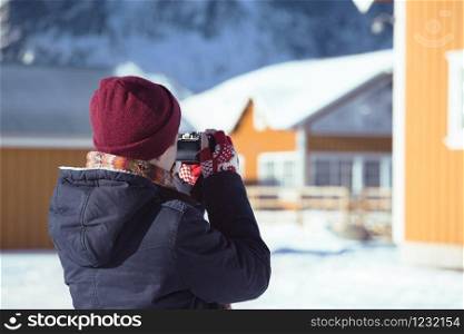 girl travels around lofoten islands and takes pictures on camera. Norway
