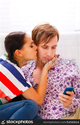 Girl trying to distract her busy boyfriend from mobile phone &#xA;