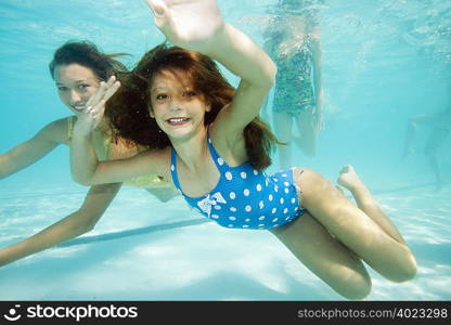 Girl underwater, smiling towards camera