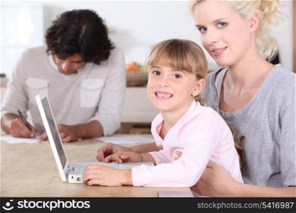 Girl using a laptop with her parents