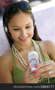 Girl Using Cell Phone While Listening to Music