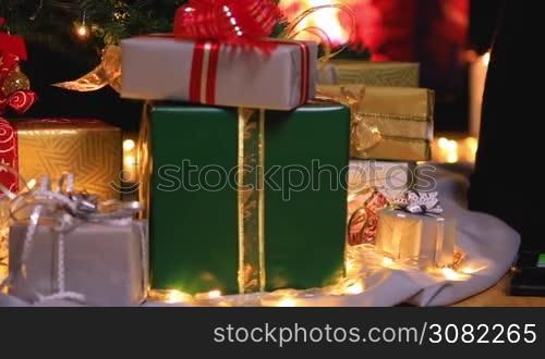 Girl using digital tablet computer near Christmas tree and gifts. Dolly shot