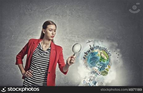 Girl using magnifier for search. Beautiful woman in red jacket looking through magnifying glass. Elements of this image are furnished by NASA
