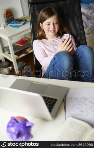 Girl Using Mobile Phone Instead Of Studying In Bedroom