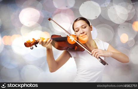 Girl violinist. Portrait of young pretty woman playing violin