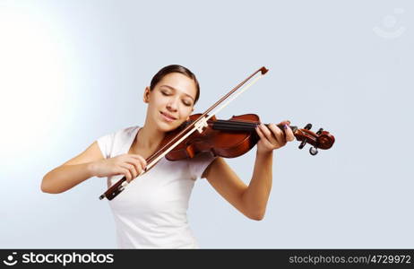 Girl violinist. Portrait of young pretty woman playing violin