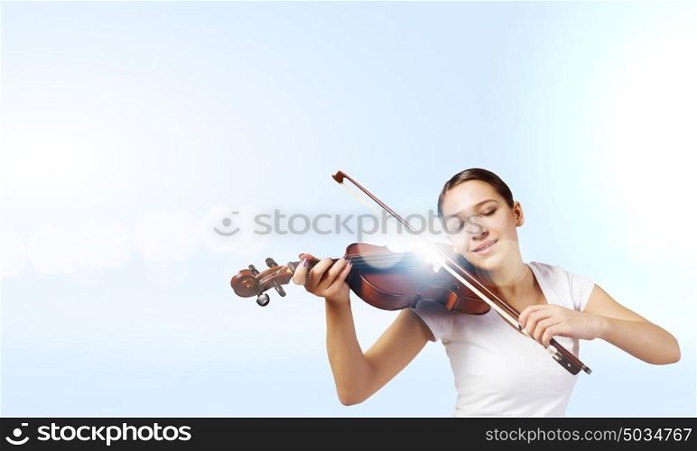 Girl violinist. Portrait of young pretty woman playing violin