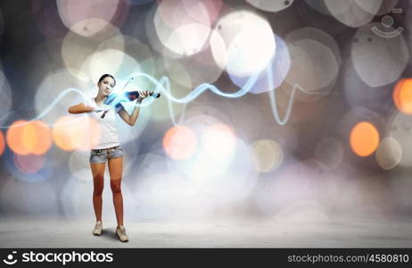 Girl violinist. Young girl in shorts and shirt playing violin