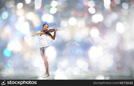 Girl violinist. Young girl in shorts and shirt playing violin