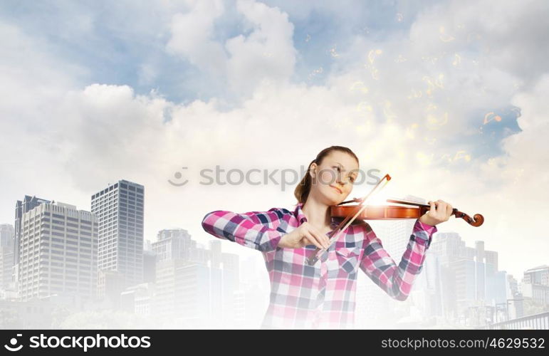 Girl violinist. Young pretty woman in casual playing on violin