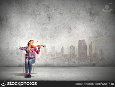 Girl violinist. Young pretty woman in casual playing on violin