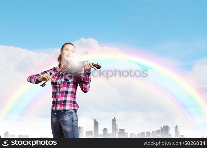 Girl violinist. Young pretty woman in casual playing on violin