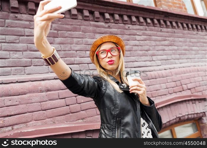 Girl visiting tourist attractions. Woman taking selfie with smart phone in street of city