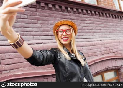 Girl visiting tourist attractions. Woman taking selfie with smart phone in street of city