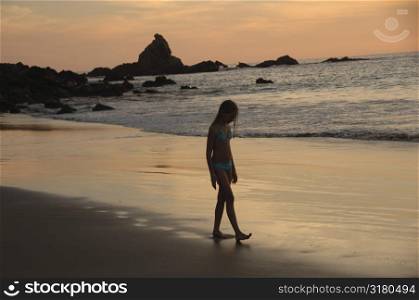 Girl walking along beach