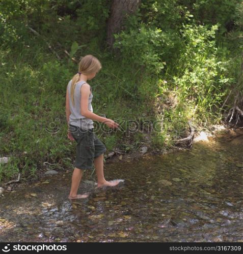 Girl walking in stream of water