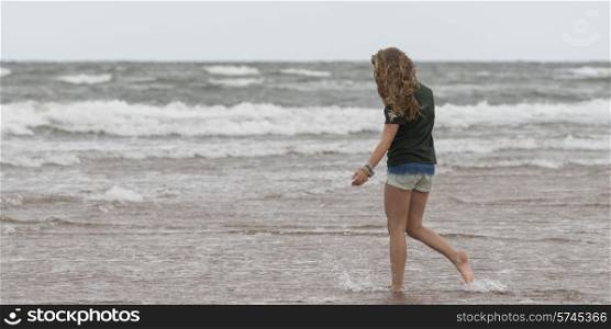 Girl walking on the beach, Prince Edward Island, Canada