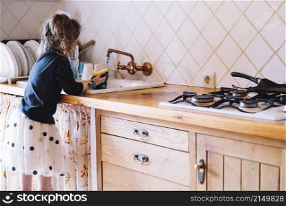 girl washing cup kitchen sink