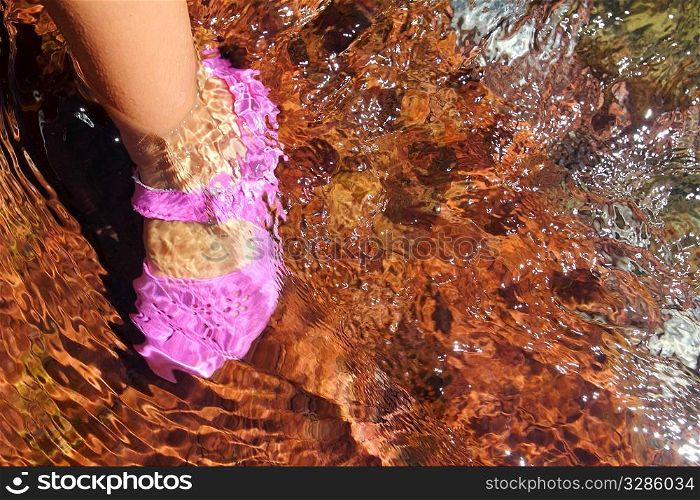 Girl water feet pink shoe in river stream red bottom rolling stones