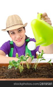 Girl watering plants on white