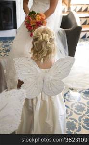 Girl wearing butterfly wings at wedding ceremony