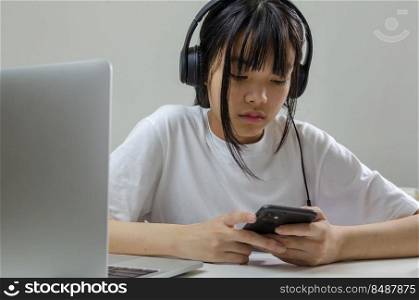 girl wearing headphones studying online with computer laptop and listen to relaxing music or play internet social media at home.