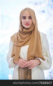 Girl wearing hijab posing on winter concept background. Portrait of modern muslim woman representing islamic fashion.