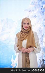 Girl wearing hijab posing on winter concept background. Portrait of modern muslim woman representing islamic fashion.