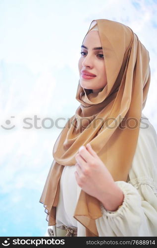 Girl wearing hijab posing on winter concept background. Portrait of modern muslim woman representing islamic fashion.