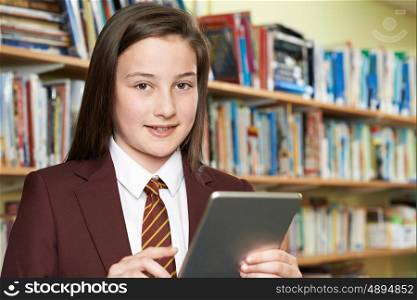 Girl Wearing School Uniform Using Digital Tablet In Library