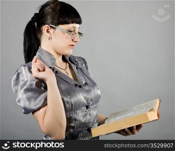 girl wearing spectacles and with the book in hands