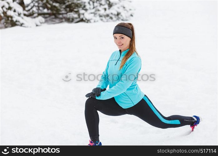 Girl wearing sportswear and doing stretching exercises on snow. Winter sports, outdoor fitness, fashion, workout, health concept.. Winter workout. Girl wearing sportswear, stretching exercises.