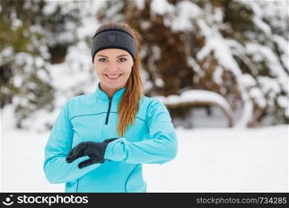 Girl wearing sportswear checking watch on wrist. Winter sports, outdoor fitness, fashion, workout, health concept.. Winter workout. Girl wearing sportswear checking time