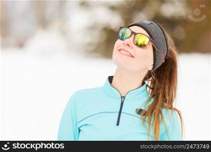 Girl wearing sportswear looking at the sky and smiling. Winter sports, outdoor fitness, fashion, workout, health concept.. Winter workout. Girl wearing sportswear and sunglasses.
