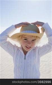 Girl wearing straw hat on beach