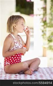 Girl Wearing Swimming Costume Blowing Bubbles