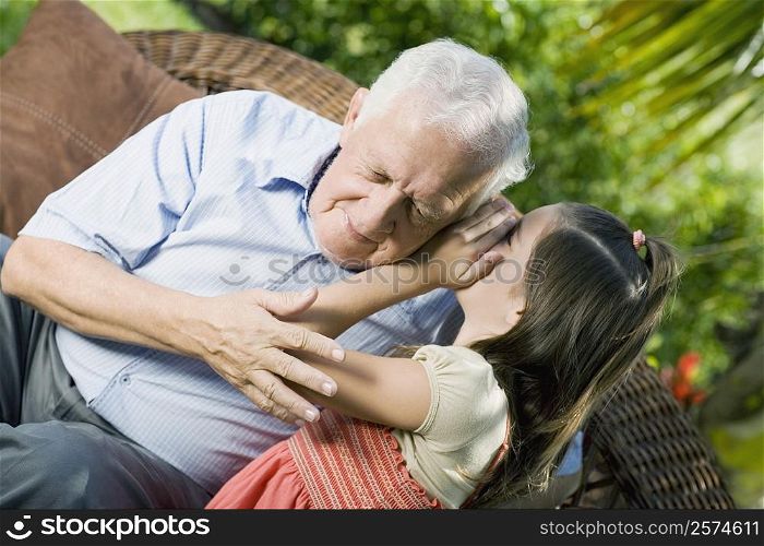 Girl whispering into her grandfather&acute;s ear