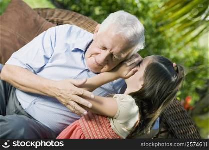 Girl whispering into her grandfather&acute;s ear