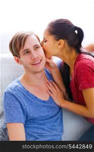 Girl whispering something in ear of her excited boyfriend&#xA;