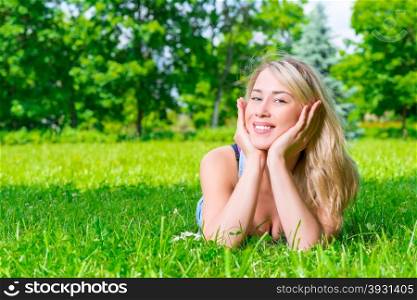 girl with a beautiful smile posing lying on the grass