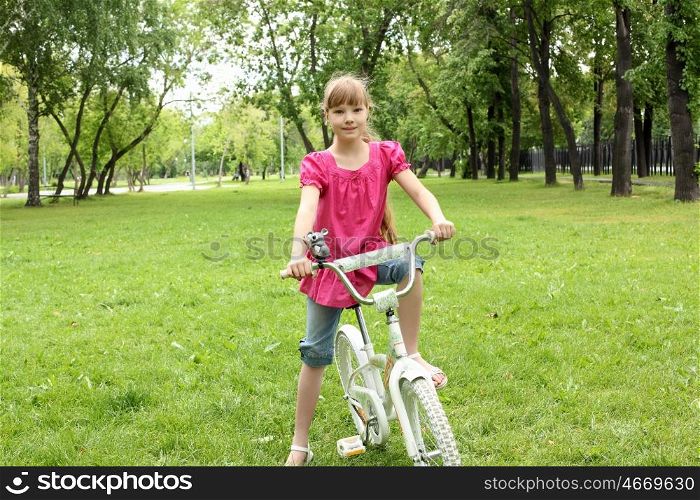 Girl with a bike in the summer park