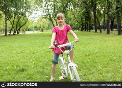 Girl with a bike in the summer park