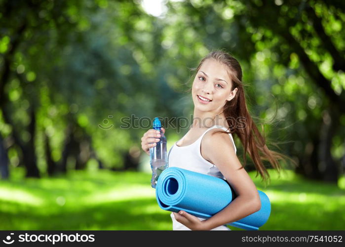 Girl with a bottle of water and gymnastic mats turn