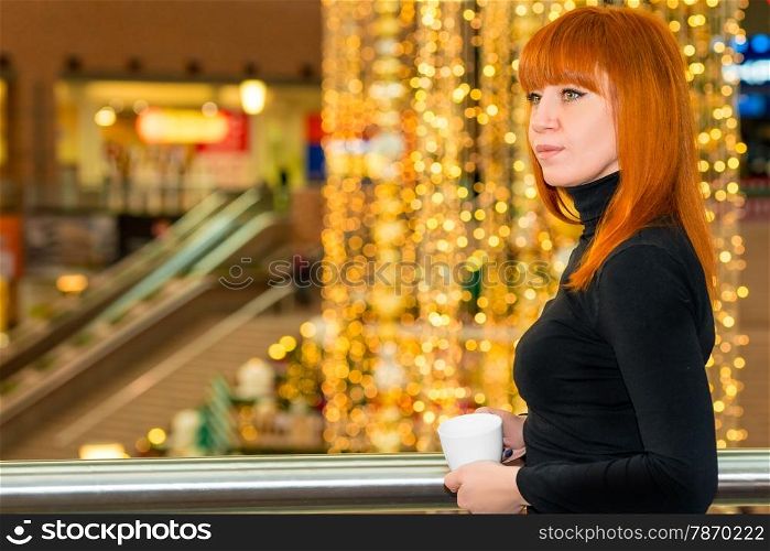 girl with a coffee in the mall before Christmas