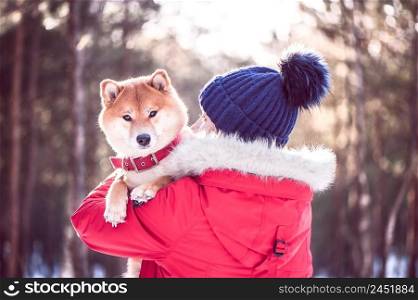 Girl with a dog in her arms. The concept of friendship between a dog and a man. Shiba inu and the girl