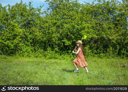 Girl with a ring on a summer field. Sunny day. smiling girl holding a butterfly net on a blue sky with clouds. Girl with a ring on a summer field. Sunny day.