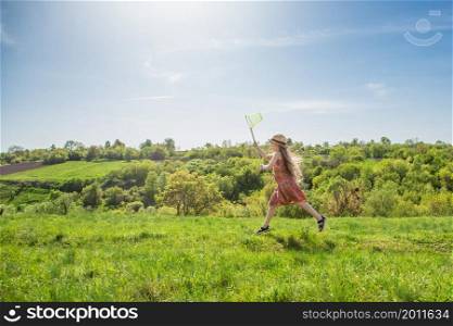 Girl with a ring on a summer field. Sunny day. smiling girl holding a butterfly net on a blue sky with clouds. Girl with a ring on a summer field. Sunny day.