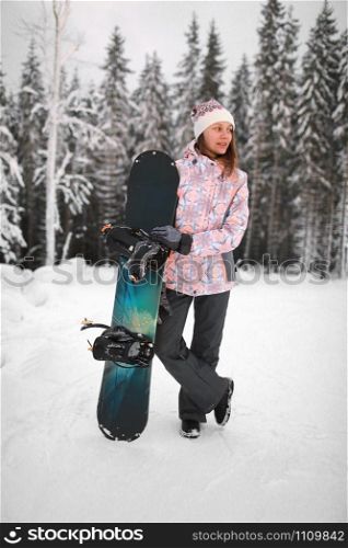girl with a snowboard in the mountains. happy smiling young woman with snowboarding on the mountain in winter.. girl with a snowboard in the mountains. happy smiling young woman with snowboarding on the mountain in winter
