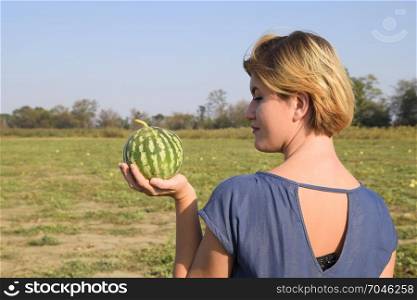 Girl with a watermelon in her hand. Search for watermelons in the field of melons. Found a watermelon.. Girl with a watermelon in her hand. Search for watermelons in the field of melons. Found a watermelon
