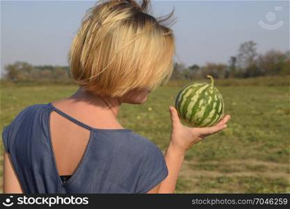 Girl with a watermelon in her hand. Search for watermelons in the field of melons. Found a watermelon.. Girl with a watermelon in her hand. Search for watermelons in the field of melons. Found a watermelon